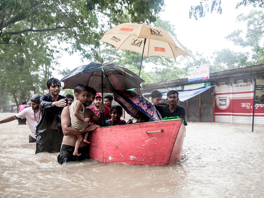 Local volunteers rescue women and children trapped in floodwaters and transport them to shelters in Feni, Bangladesh,