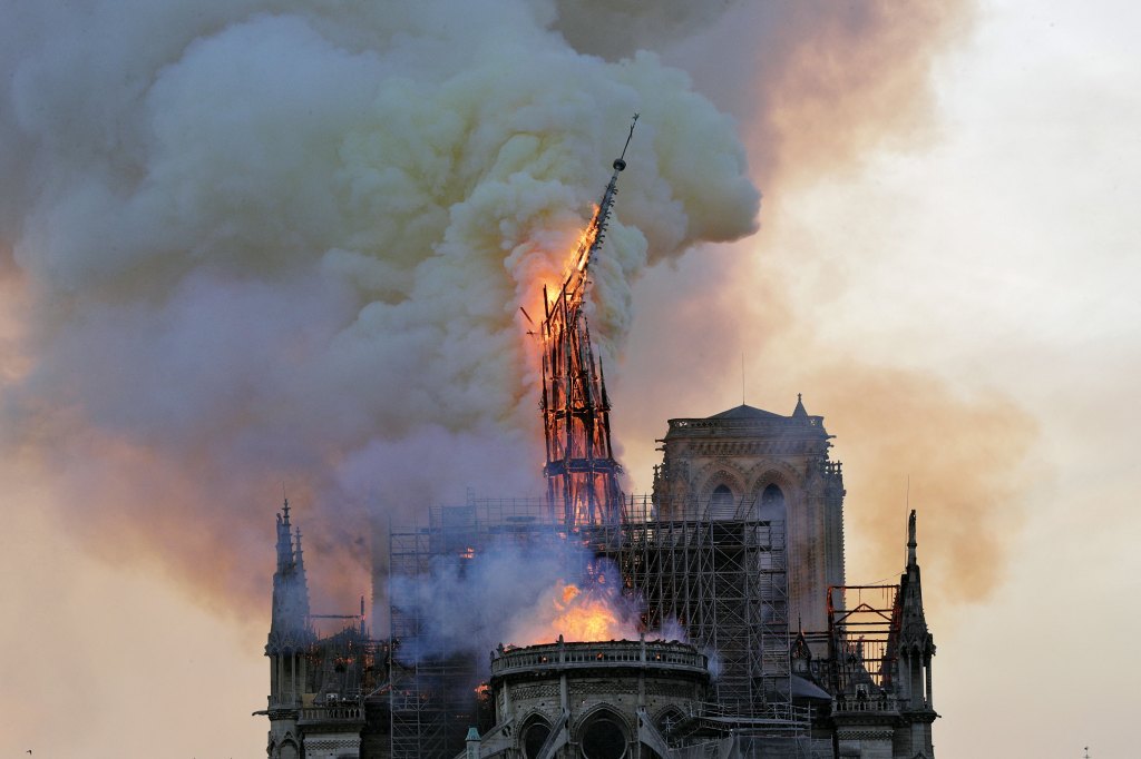 The historic spire of the Notre-Dame de Paris Cathedral engulfed in flames and smoke just before collapsing during the 2019 fire.