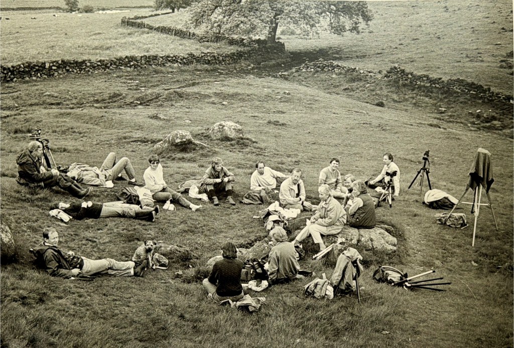 monochrome photo of people having lunch in the field