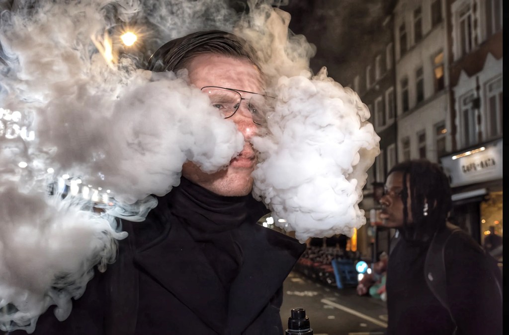 man blowing smoke out his nose
