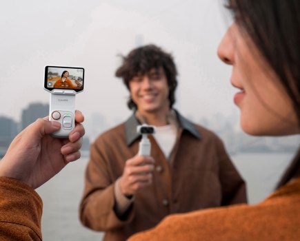 Insta360 Luna Ultra's detachable monitor held up while another person holds the main camera body