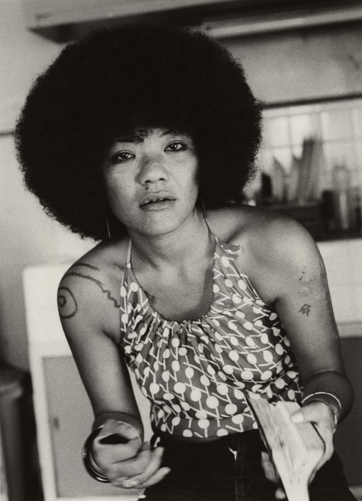 Black and white photograph of a woman with afro hair posing for the camera.