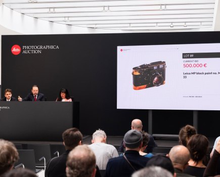 People sitting at a Leica camera auction