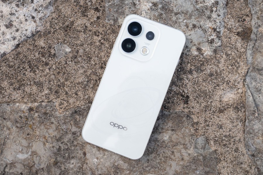 White Oppo Reno 16 pro placed on a grey rock