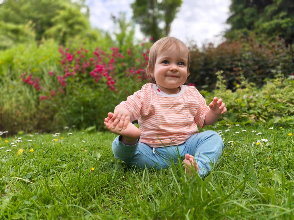 Oppo Reno 16 Pro portrait sample, baby sitting in a park