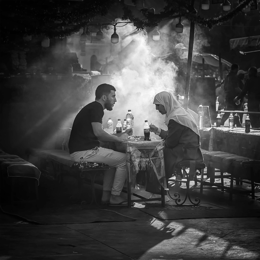 a couple enjoying a meal in the Jemaa el-Fnaa square and market quarter of Marrakesh, Morocco