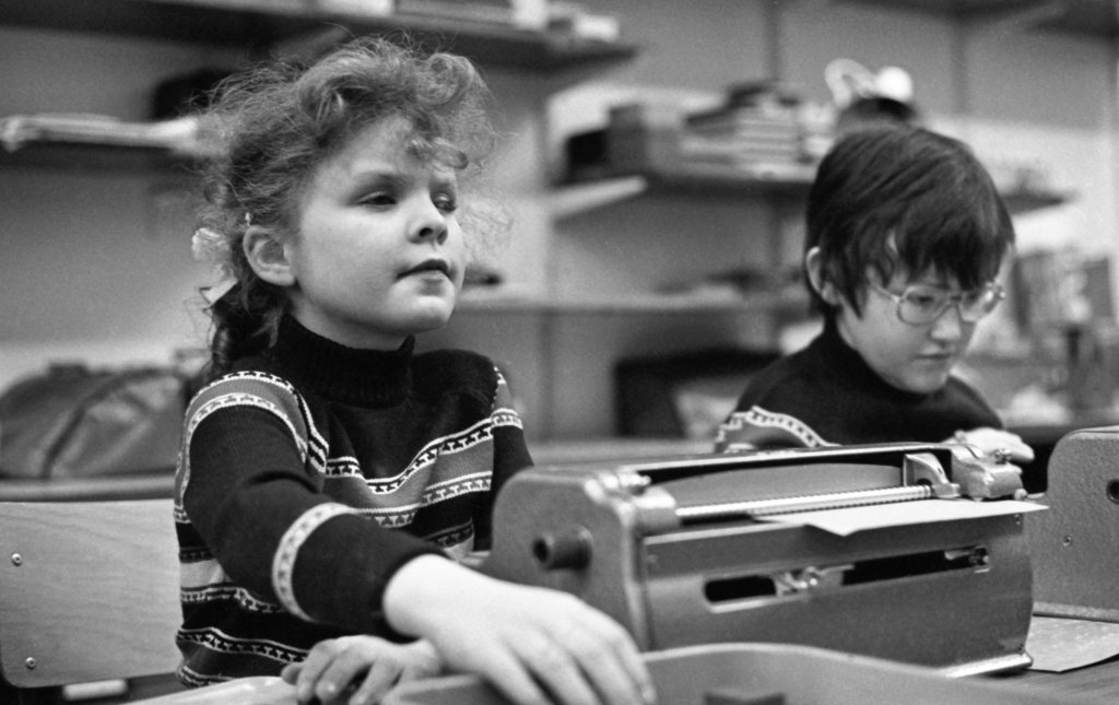 Blind children learning how to type on a typewriter