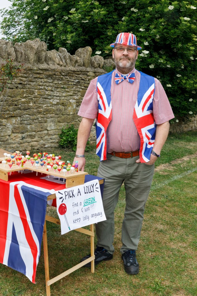 The Vicar Si Dunn. V.E. Celebrations, Lacock, Wiltshire, England, 2025. Image Credit: Martin Parr/Magnum Photos