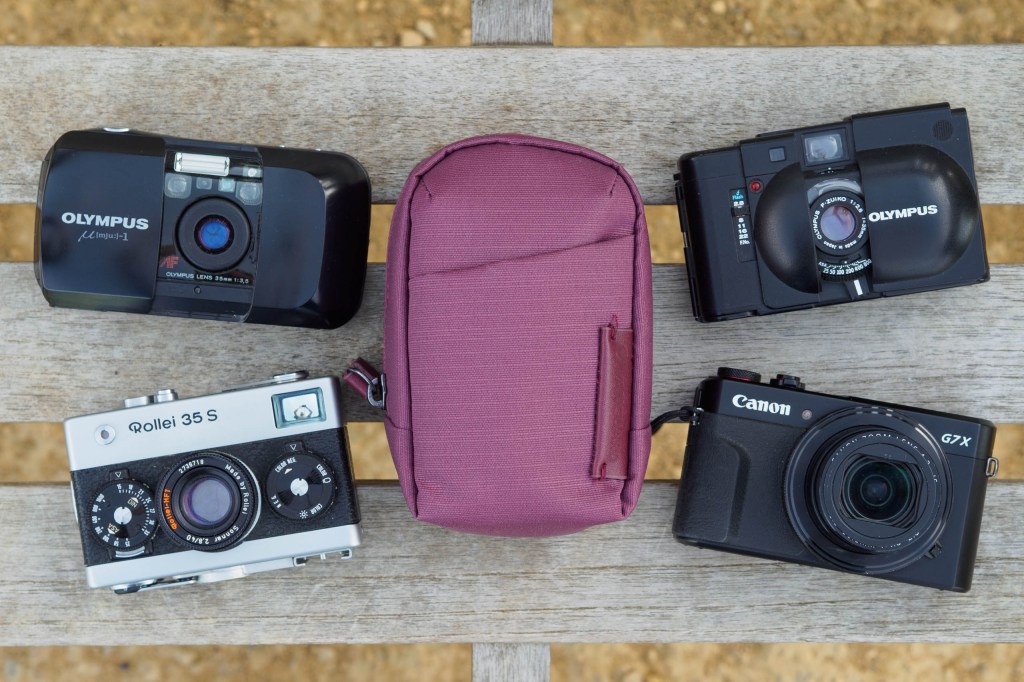 Vanguard VEO Metro Small Compact Camera Bag in Burgundy, with a selection of cameras that will fit inside. Image credit: Andy Westlake 