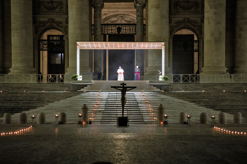 A dramatic photo of Pope Francis walking alone through a completely empty, rain-slicked St. Peter's Square during the 2020 pandemic.