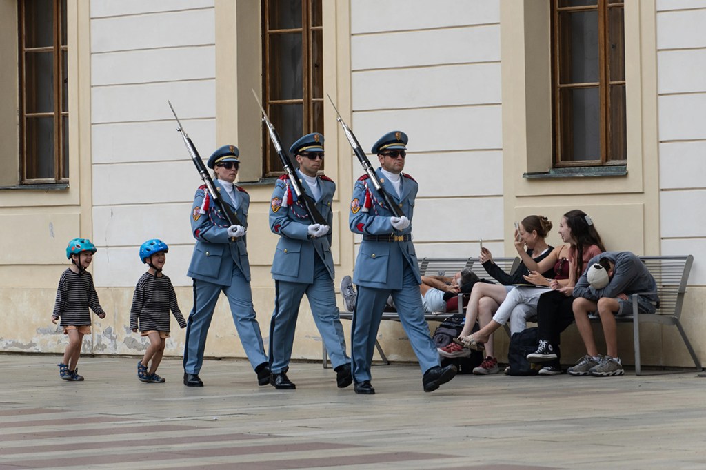 two children mimicking guards they are walking behind