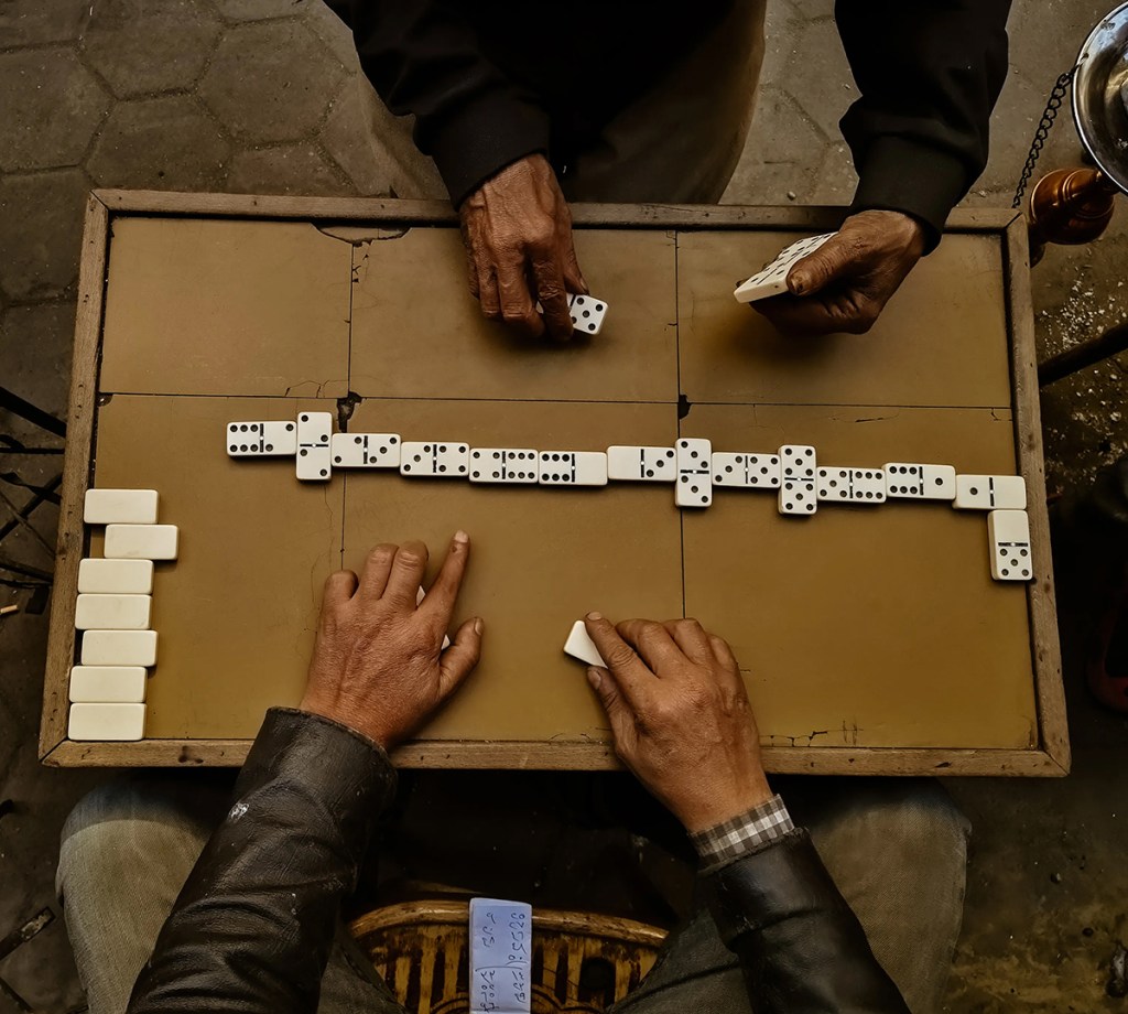 overhead shot of people playing dominoes