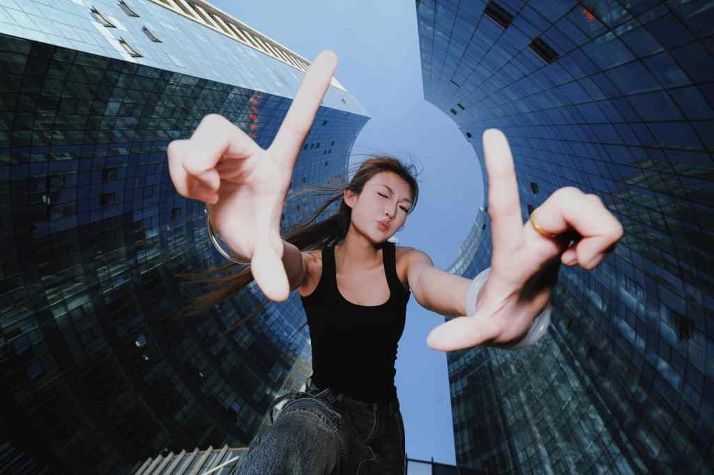 Brightin Star 14mm F2.8 lens sample, portrait image of a woman framed by skyscrapers looking down into the camera lens