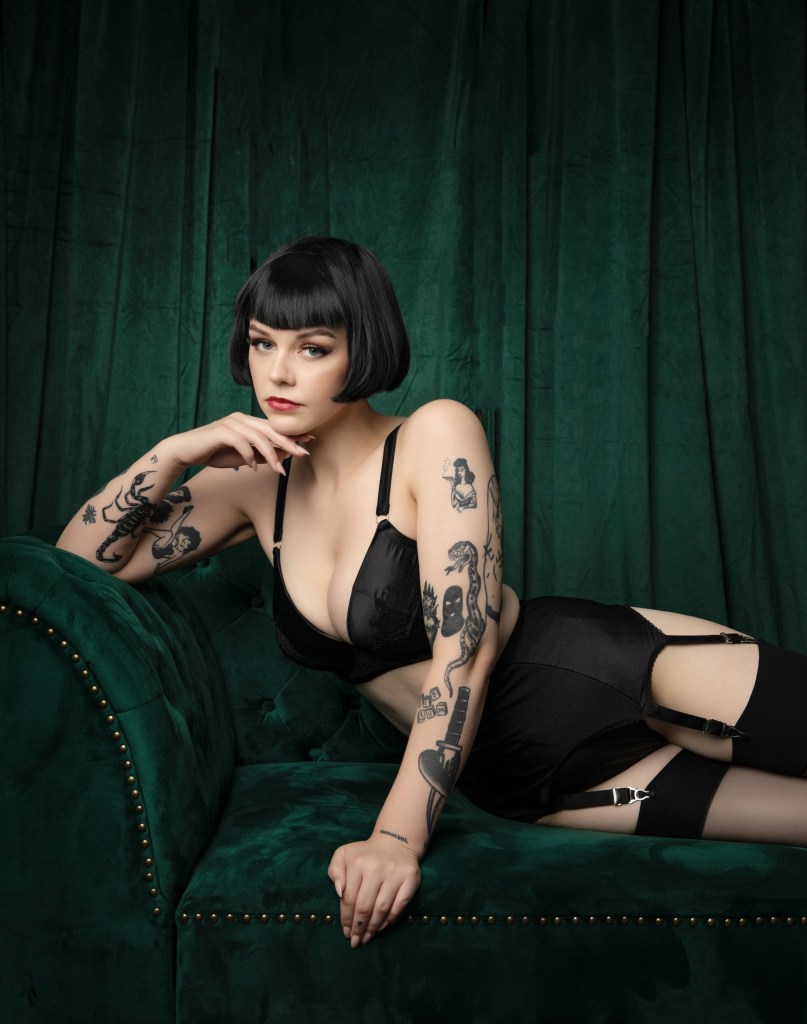 A woman in lingerie posing in front of a green backdrop