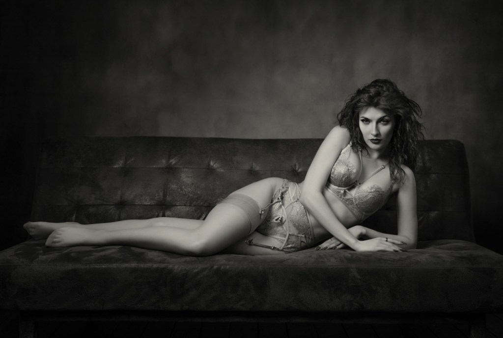 A woman in lingerie posing on a sofa