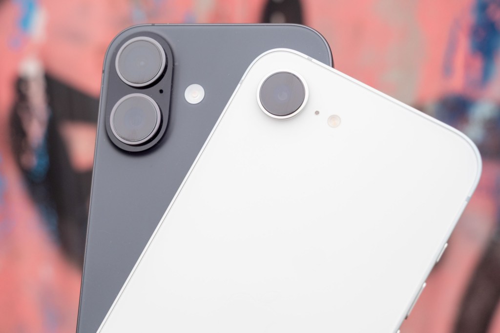 iPhone 17 and iPhone 17e in hand against a graffitied wall