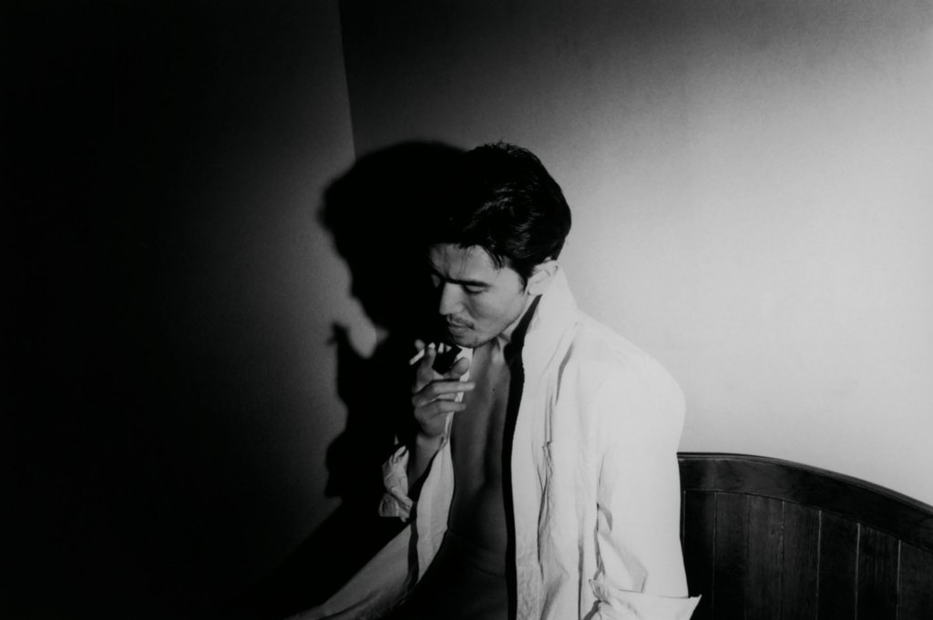 Black and white portrait of a man smoking a cigarette.