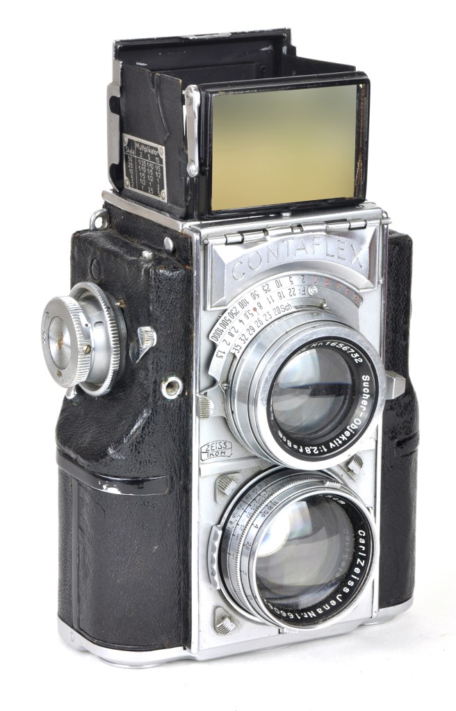 The 1935 Contaflex was an unusual twin lens reflex made for 35mm film, and the first camera equipped with a built-in photoelectric exposure meter. The shooting lens focal length was 50mm, but the viewing lens was 80mm to give a slightly larger than 35mm size format on the viewfinder screen