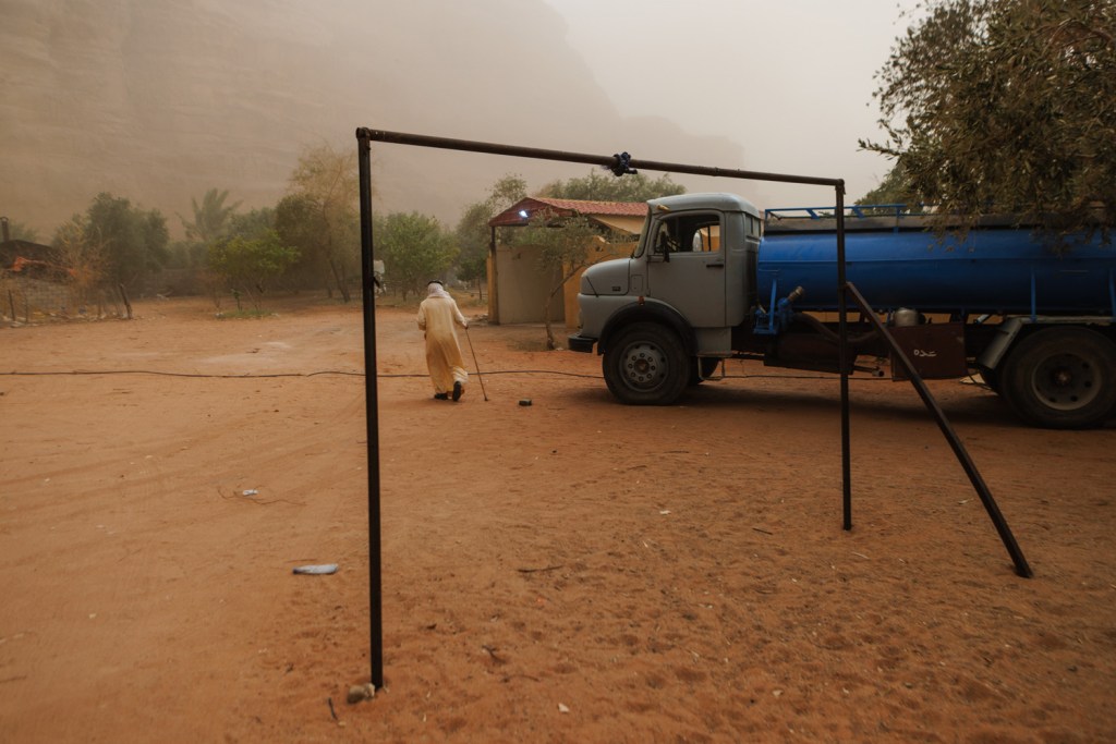 Against the backdrop of a swirling sandstorm in the Wadi Rum desert, 71-year-old 
Mohammad Al Zawaideh navigates the landscape, Jordan 2025. From the series  
“We Used to Watch the Rivers Go By”
© Annie Sakkab/LOBA 2026
