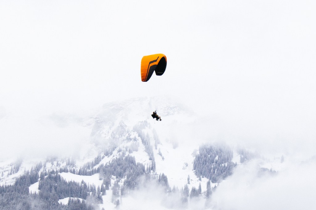 paragliding through a snowy mountain scene