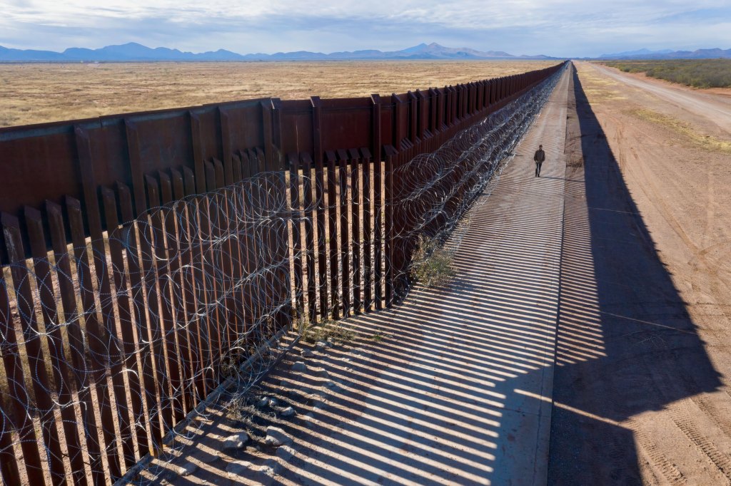 Mexico border fence with a person walking in between two gences