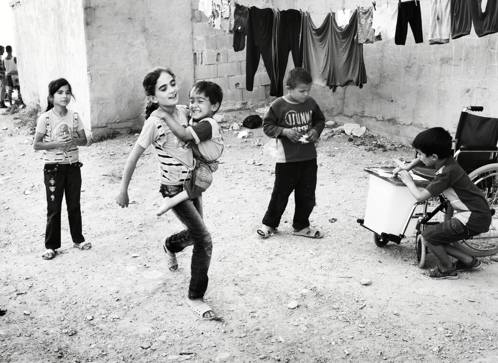 Aya playing hopscotch with her sister Iman. Tripoli, Lebanon 2014. Image Credit: Giles Duley