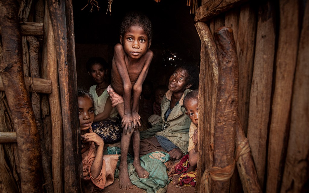 Horariby, (mother of of 4) looks at her badly malnourished daughter surrounded by the rest of her family. Marofoty village: “My children are unusually tired and don’t play very often,” she says, “I just want them to have a full belly and go to school, but that feels like a stretch – we don’t have enough food. All I can do is hope for rain.” Image Credit © Simon Townsley