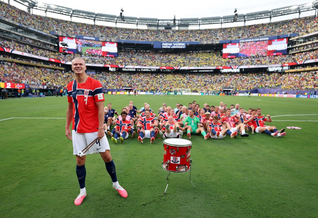 World Cup image Erling Haaland stands in front of the Norway team whos 'rowing' on the grass