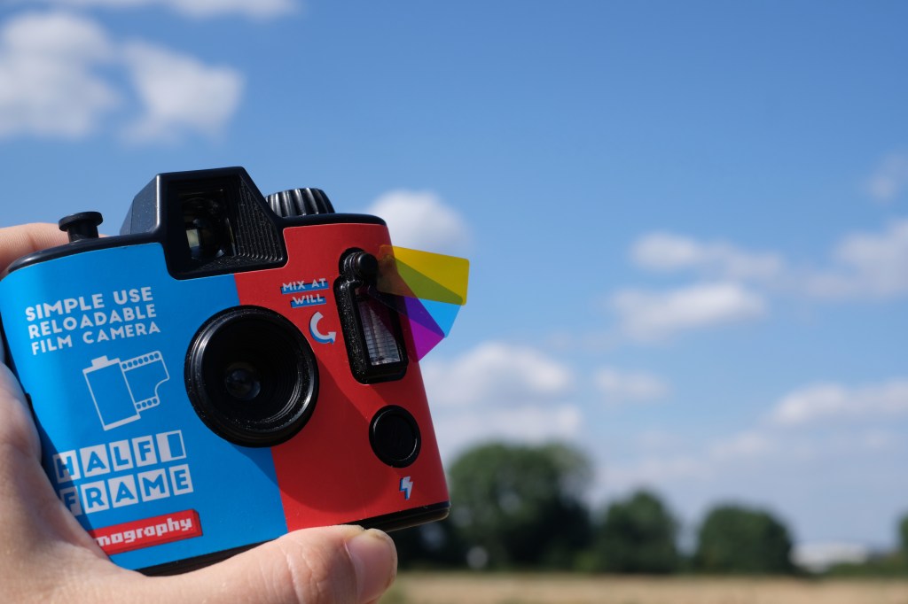 Photograph of the Lomography Half-frame Simple Use Camera from the front showing coloured flash gels extended