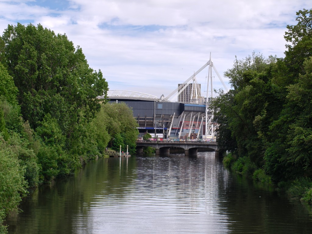Oppo Reno 16 Pro, image sample, river with trees on either side and a bridge in the distance with a modern building telephoto camera