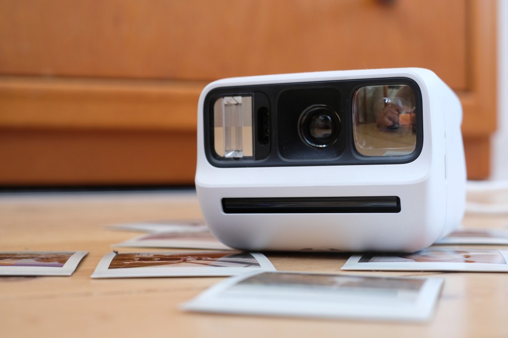 Polaroid Go Gen 3 sitting on a pile of Polaroid photos