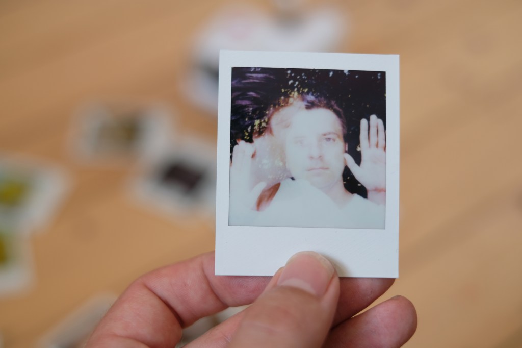 Double exposure photograph of a man turning his head and holding up his hands