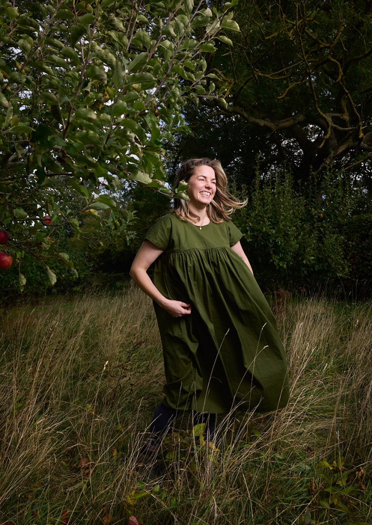 'Where I Grow' from Rooted In Her. Standing on the fields of her childhood home, Claire smiles, deeply grounded and nurtured by the earth. The lush greenery and textured landscape offer a visual sanctuary, echoing her inner peace. Here, Claire shares her journey of connecting with flowers through the lens of womanhood. For her, this field did not just occupy space, it actively opened the threshold into motherhood and a profound era of personal development.