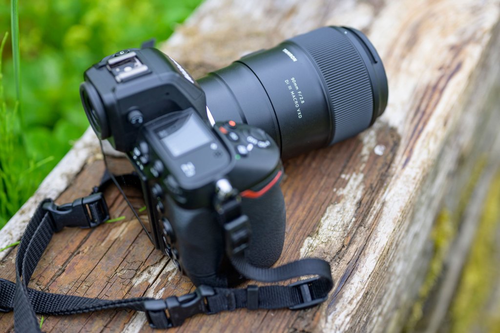 Top down, three quarters view of the Tamron 90mm F2.8 Di III Macro VXD lens mounted on a Nikon Z8 camera