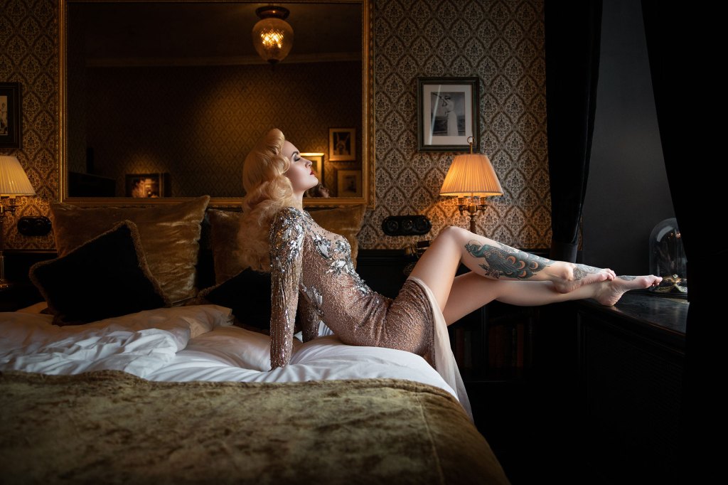 Boudoir photo of a woman posing on the edge of a bed