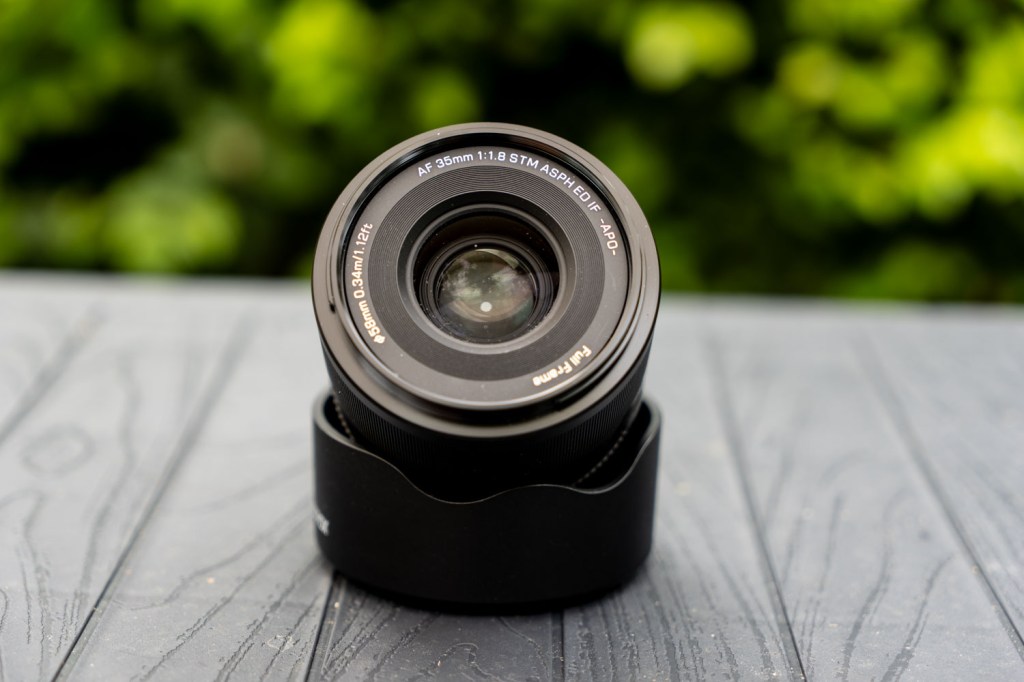 Viltrox AF 35mm F1.8 EVO II positioned askew on top of its lens hood, with the front of the lens showing