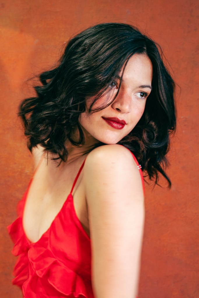 portrait of a woman with a short brunette bob in a red dress