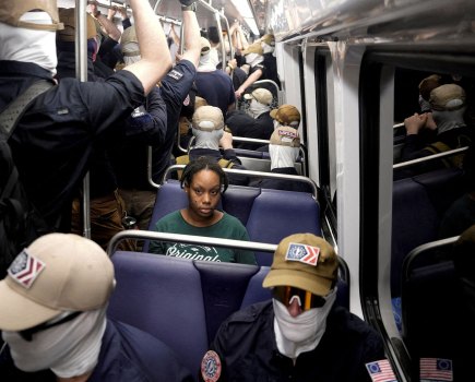 A commuter sits as members of the group Patriot Front ride the metro on the Fourth of July in Washington. REUTERS/Cheney Orr