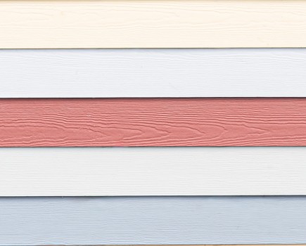 close-up photo of blue, cream and pink wood panelling on coastal hut