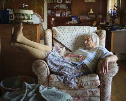 elderly woman reclined across a chair