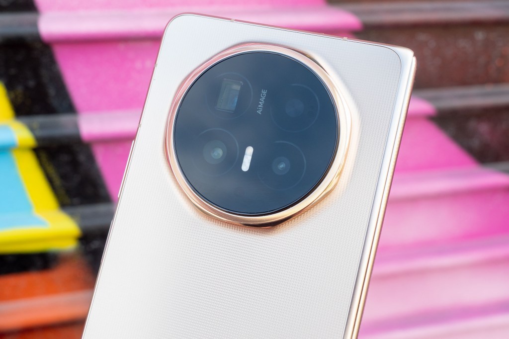 Honor Magic V6 foldable phone camera isle close up. Photographed against a pink graffiti wall.