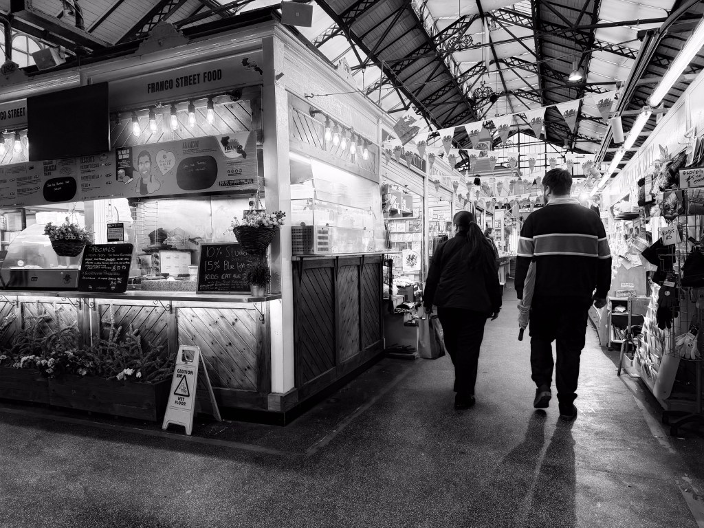 Two people walking through a busy market