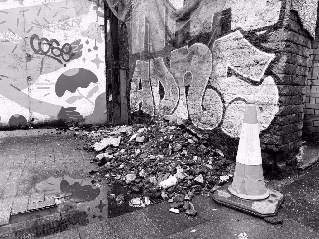 A traffic cone next to some rubble