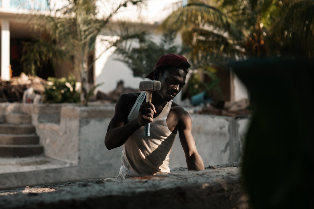 A local construction worker pulls apart a hotel swimming pool in the tropical heat and humidity Sony A7IV, Sigma 35mm f1.4 Art, f1.4 at 1/800