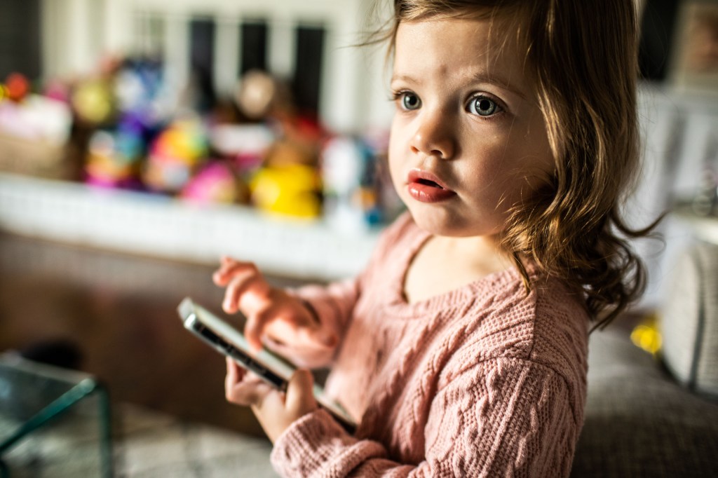 A toddler holding a smartphone